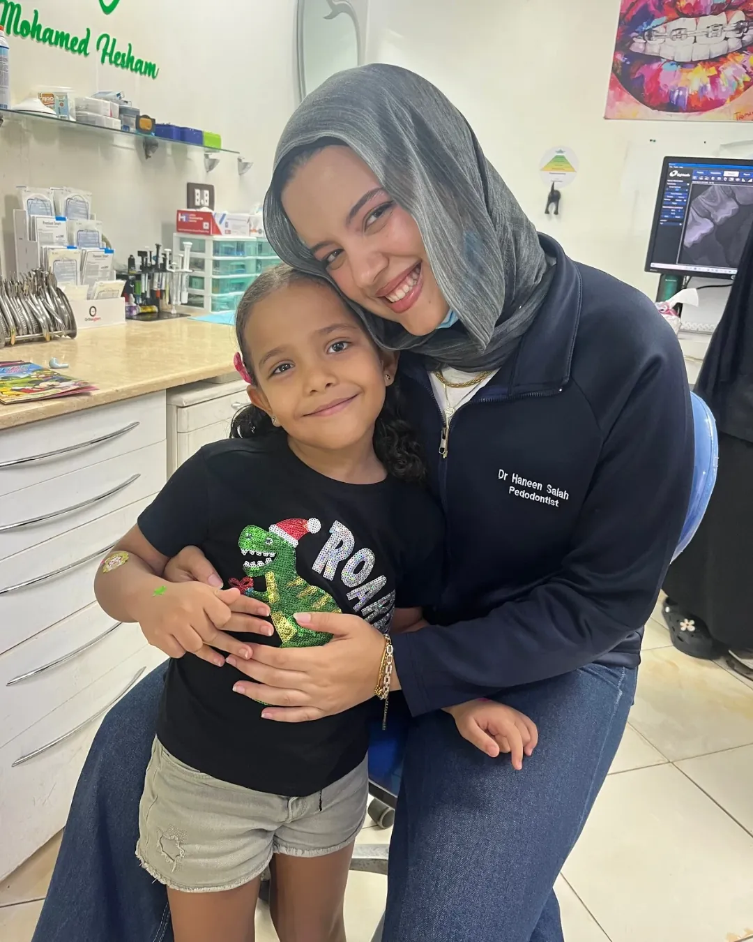 Dr. Haneen with a smiling girl at the clinic