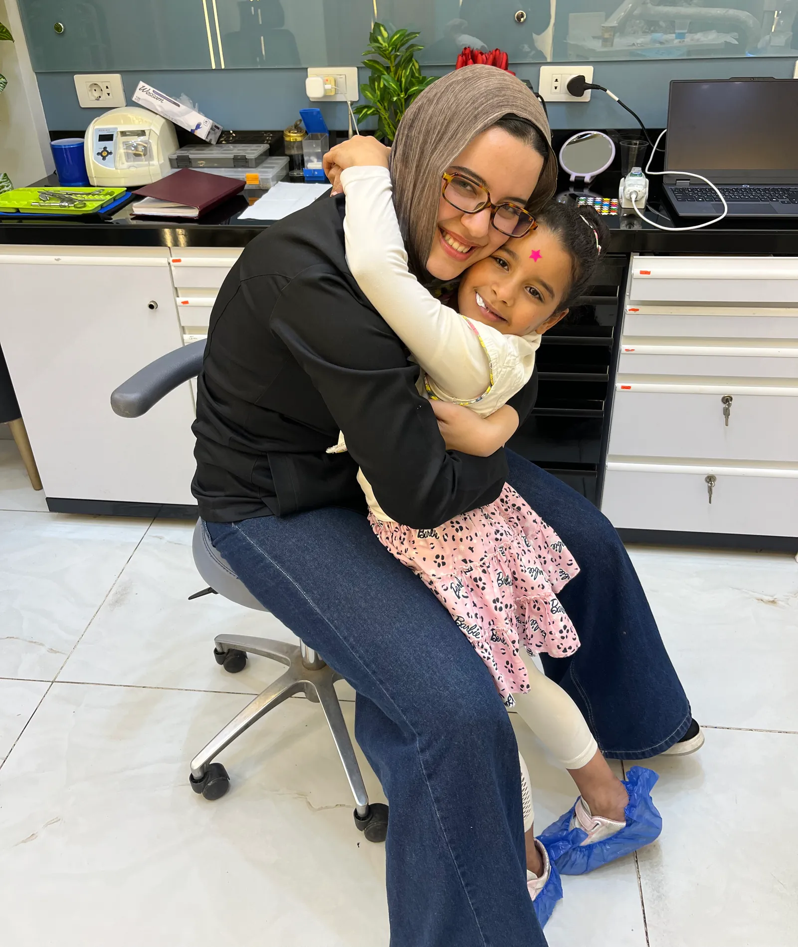 A little girl hugging Dr. Haneen after her visit