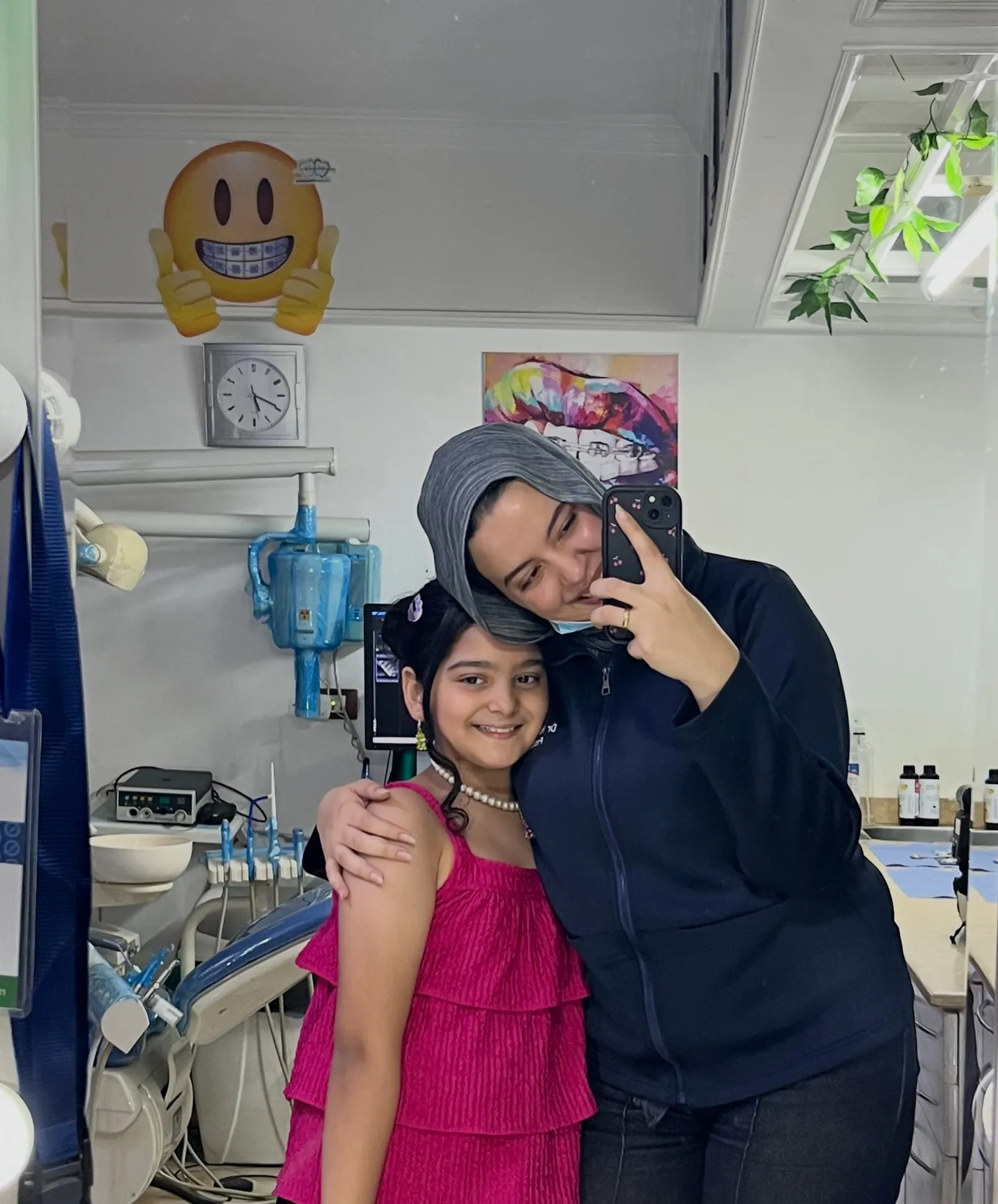 Dr. Haneen and a smiling patient at the clinic mirror