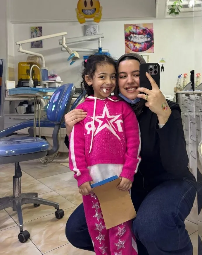 Dr. Haneen with a little girl at the clinic